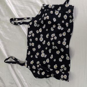 Black crop top with white and yellow flowers. Ties in the back.